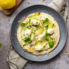 En läcker plattbrödpizza med zucchini, mozzarella och pinjenötter. Perfekt som ett snabbt mellanmål att ta med.