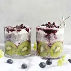 Två glas med chia vatten, kiwi och blåbär. En hälsosam frukost eller mellanmål.