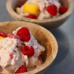 Två skålar med krämig proteinglass, toppad med hallon och mangobitar. Ett perfekt recept för en hälsosam dessert.