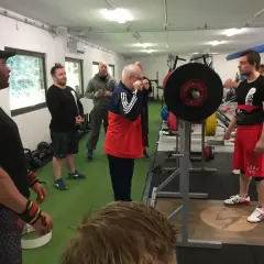 Män i gym klara för styrkelyftsträning. En man förbereder sig för lyft enligt sheiko programmet.