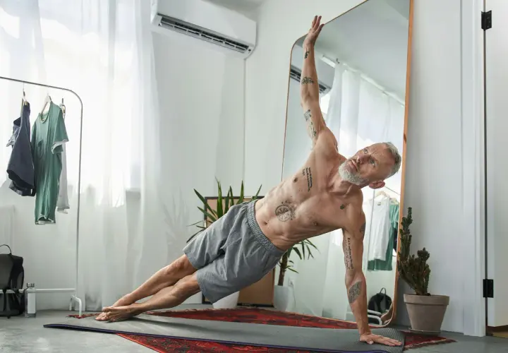 Äldre man med tatueringar gör sidoplanka. Träning kan påverka positivt på testosteron nivå ålder.