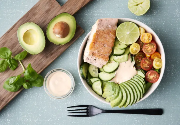Laxbowl med avokado, gurka, tomater och en krämig dressing. Ett perfekt keto diet recept för en hälsosam lunch.
