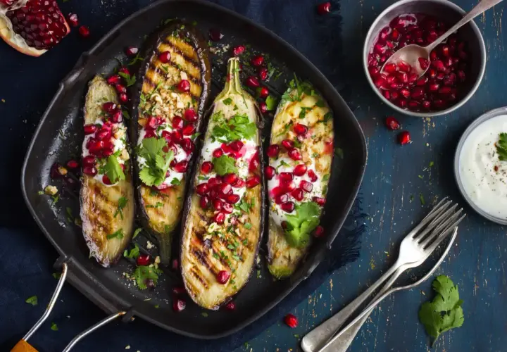 Grillade auberginehalvor toppade med yoghurt, granatäppelkärnor och nötter. Ett läckert fodmap recept som är både vackert och gott.