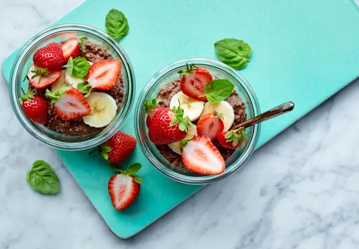 Två skålar med overnight oats kakao, toppade med jordgubbar och banan. En perfekt start på dagen!