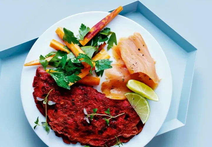 En tallrik med rödbetsplättar, lax, morötter och lime. En proteinrik måltid med cirka 100g protein.