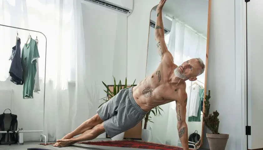 Äldre man med tatueringar gör sidoplanka. Träning kan påverka positivt på testosteron nivå ålder.