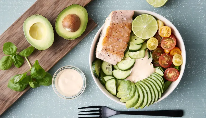 Laxbowl med avokado, gurka, tomater och en krämig dressing. Ett perfekt keto diet recept för en hälsosam lunch.