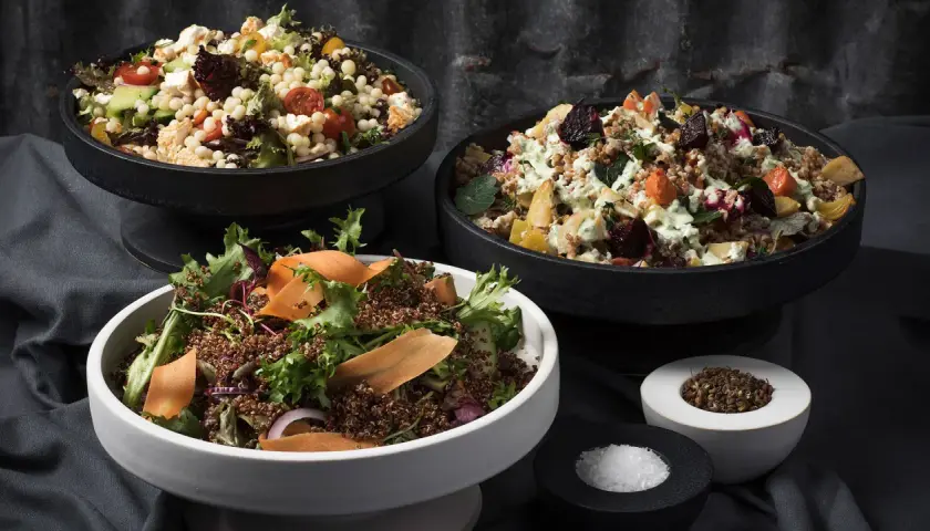 Tre skålar med nyttiga sallader: en med couscous, grönsaker och fetaost, en med rotfrukter och en med quinoa och grönsaker.