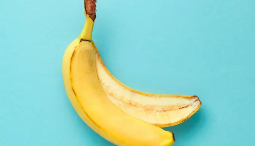En banan, delvis skalad, visar sin gula insida. Ett perfekt mellanmål som bevisar att banan nyttigt är.