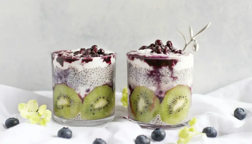 Två glas med chia vatten, kiwi och blåbär. En hälsosam frukost eller mellanmål.
