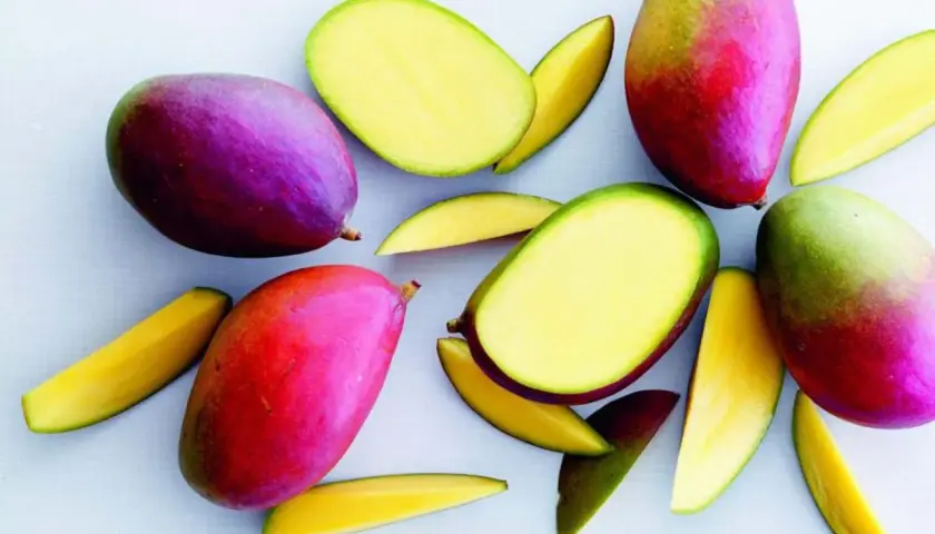 Härliga, färgglada mangos, både hela och skurna, visar hur mango nyttigt kan vara. Perfekt för en hälsosam fruktsallad.