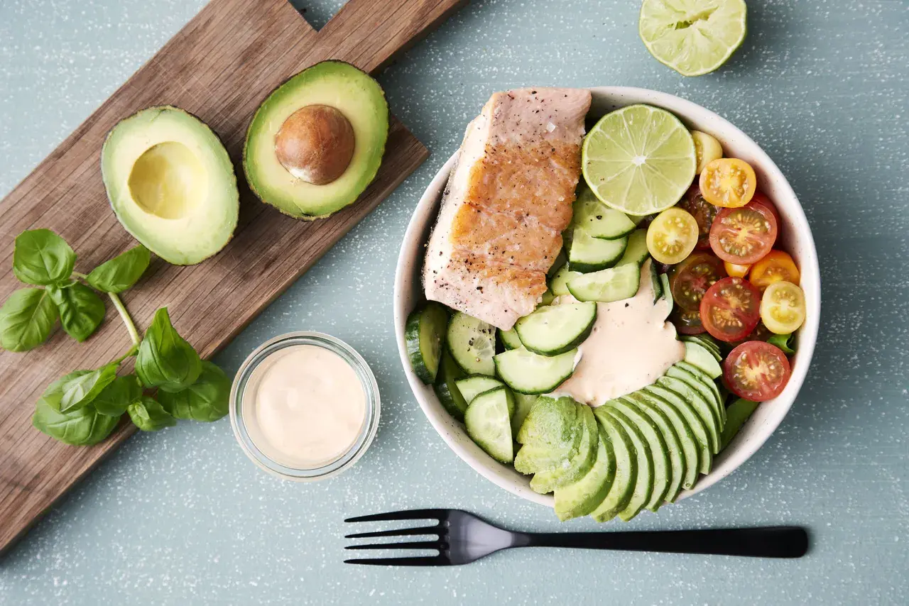 Laxbowl med avokado, gurka, tomater och en krämig dressing. Ett perfekt keto diet recept för en hälsosam lunch.