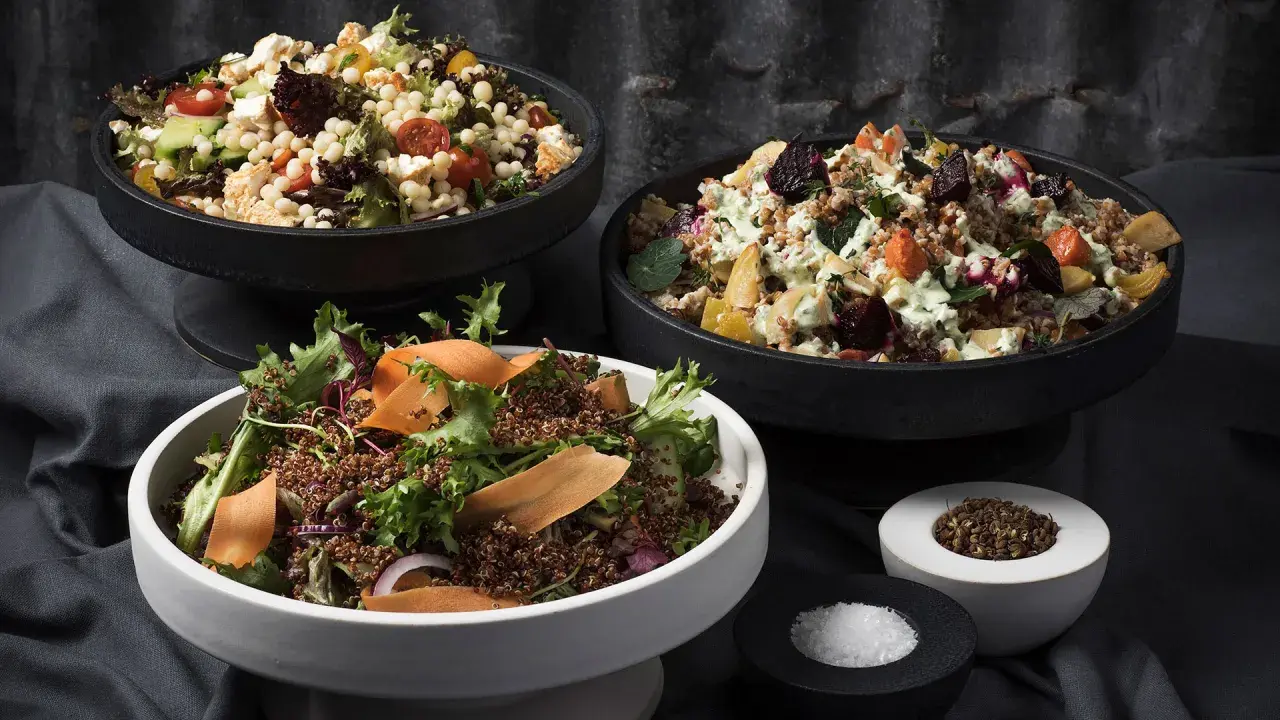 Tre skålar med nyttiga sallader: en med couscous, grönsaker och fetaost, en med rotfrukter och en med quinoa och grönsaker.