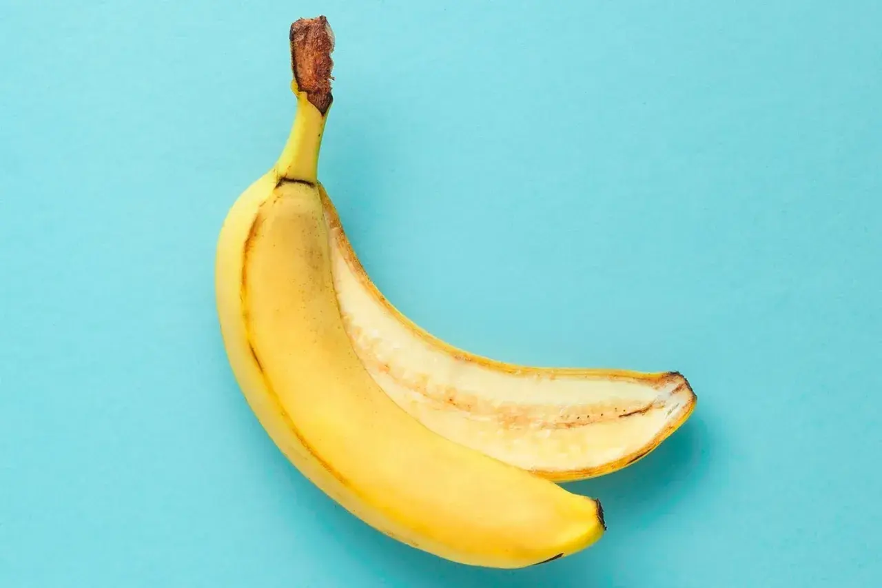 En banan, delvis skalad, visar sin gula insida. Ett perfekt mellanmål som bevisar att banan nyttigt är.