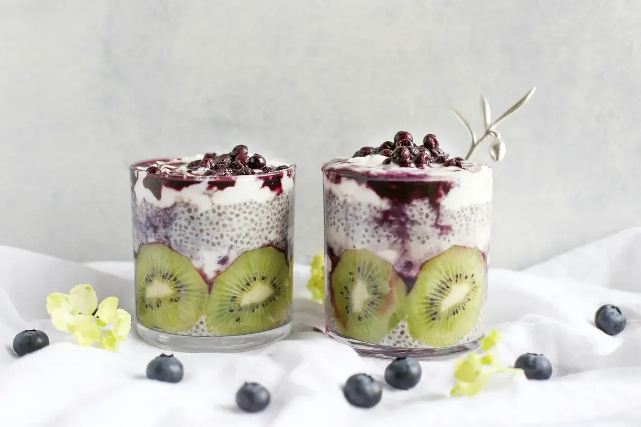 Två glas med chia vatten, kiwi och blåbär. En hälsosam frukost eller mellanmål.