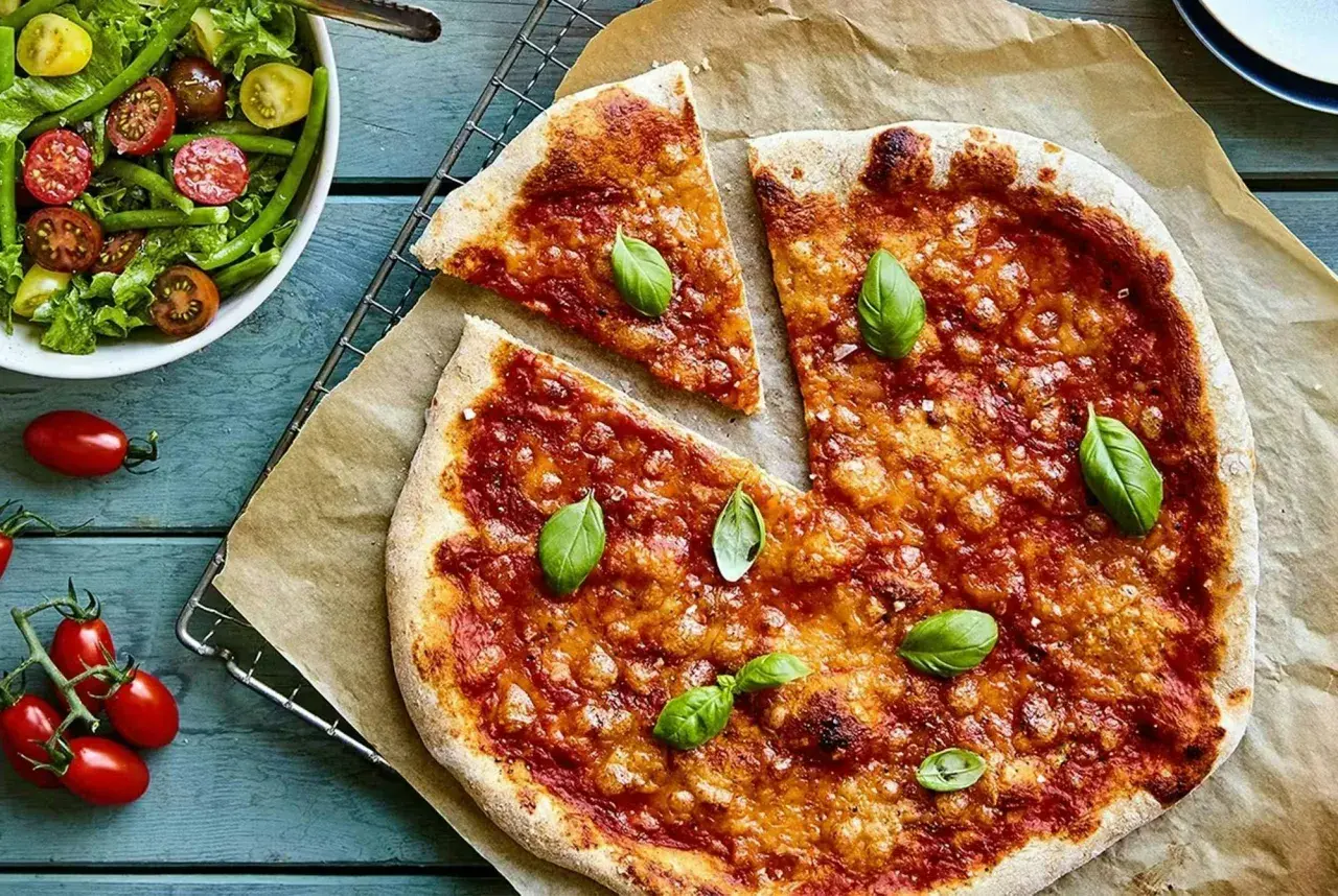 En härlig, nyttig pizza med tomatsås och ost, toppad med färsk basilika. Serveras med en fräsch grönsallad.