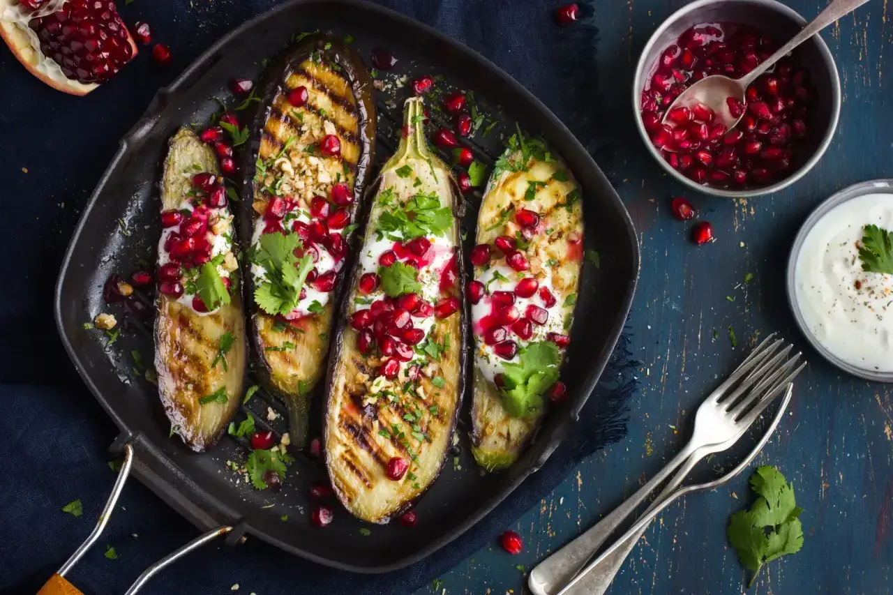 Grillade auberginehalvor toppade med yoghurt, granatäppelkärnor och nötter. Ett läckert fodmap recept som är både vackert och gott.