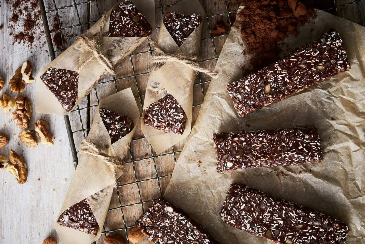 Hemmagjorda proteinbars med nötter och kokos, inslagna i papper. Perfekt för en energiboost!