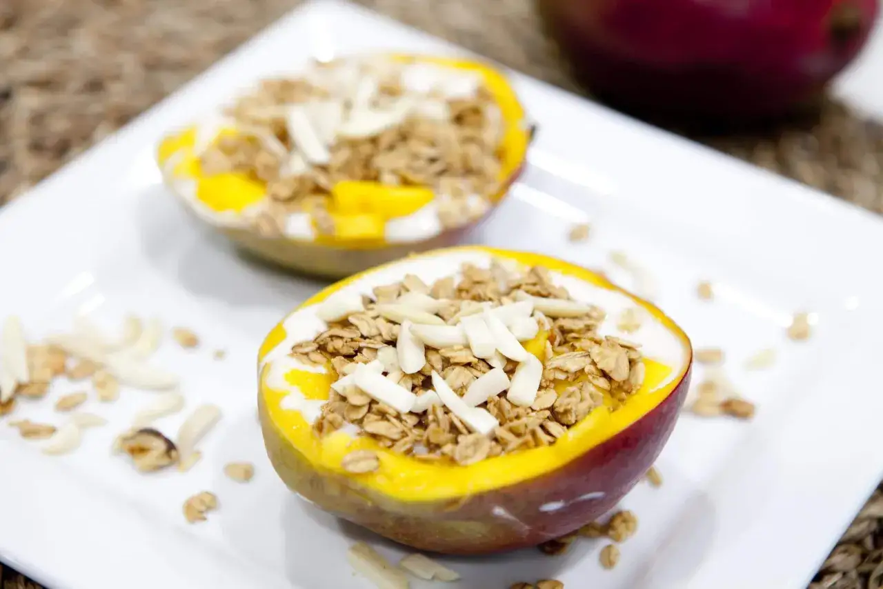 Tv&aring; halverade mangos fyllda med yoghurt, granola och mandelflagor. En perfekt och nyttig frukost eller mellanm&aring;l.